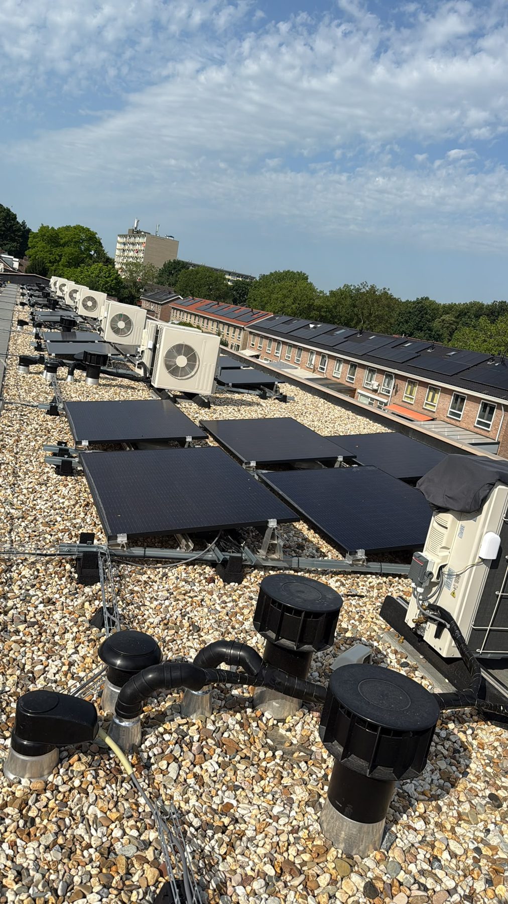 Plat dak met netjes geplaatste buitenunits naast zonnepanelen